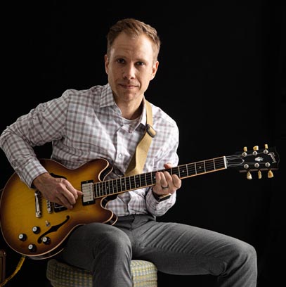 Prairie Dog Brewing board member and Chartered Accountant, Clayton Achen, playing guitar.