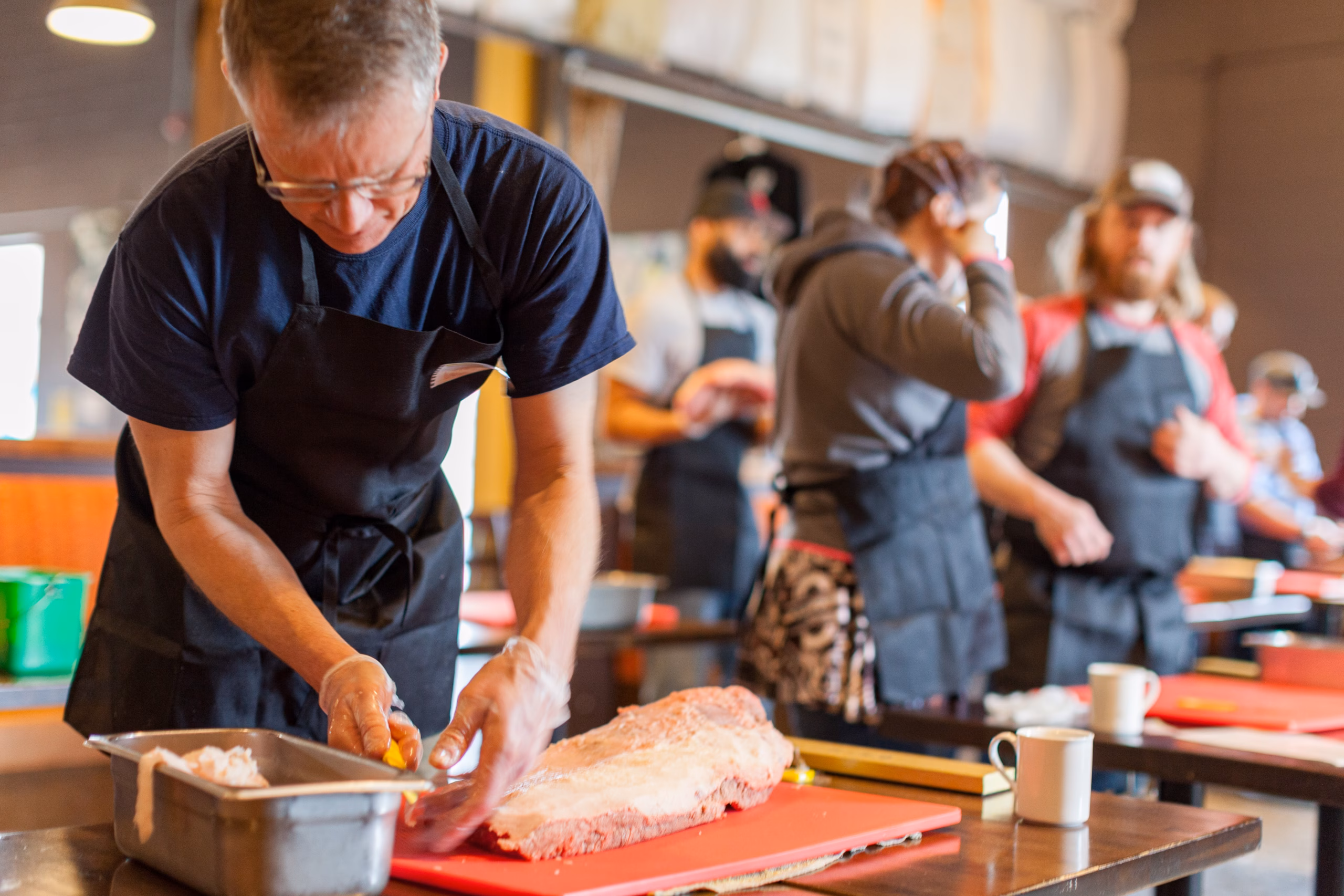 A Prairie Dog Brewing Brisket Workshop attendee trims a cut of beef brisket.