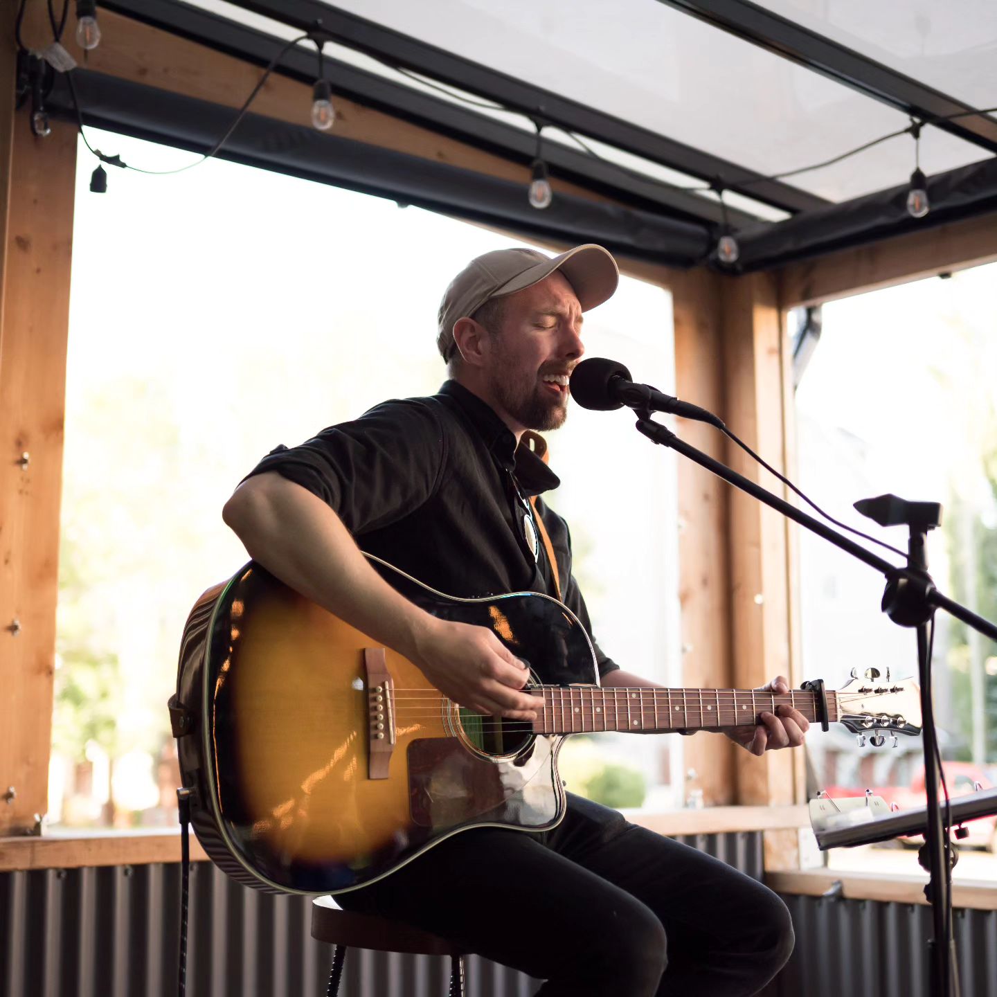 Calgary musician Daniel Hanrahan plays acoustic guitar and sings on stage at an area pub.