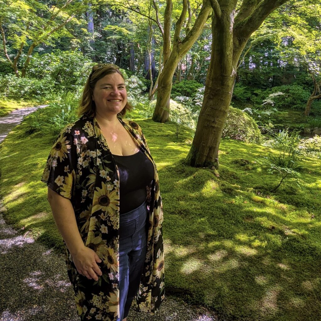 Prairie Dog Brewing co-founder Laura Coles stands in a brilliant green Japanese garden in British Columbia.